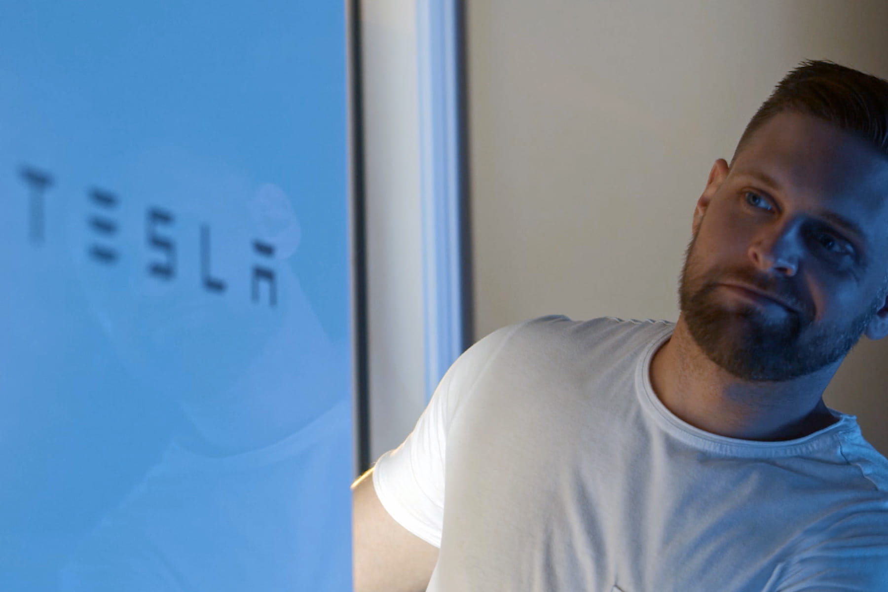 a man looking at a Tesla solar battery