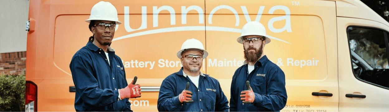 Sunnova team with hardhats and safety glasses giving a thumbs up that the solar system is running.